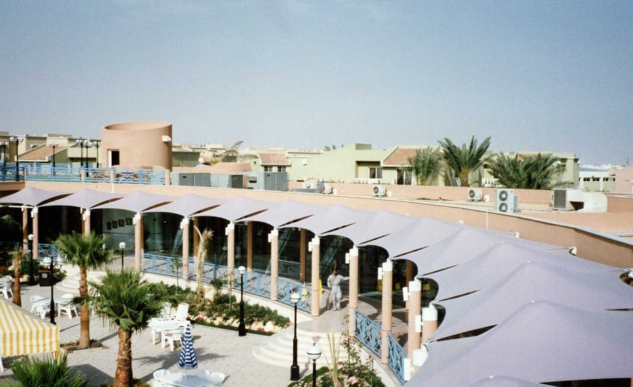 Tensile fabric canopies surrounding swimming pool