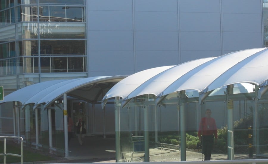 Tensile fabric canopies covering walkway