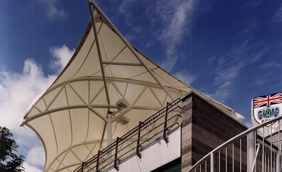 Dramatic wing like tensile fabric roof over silverstone clubhouse